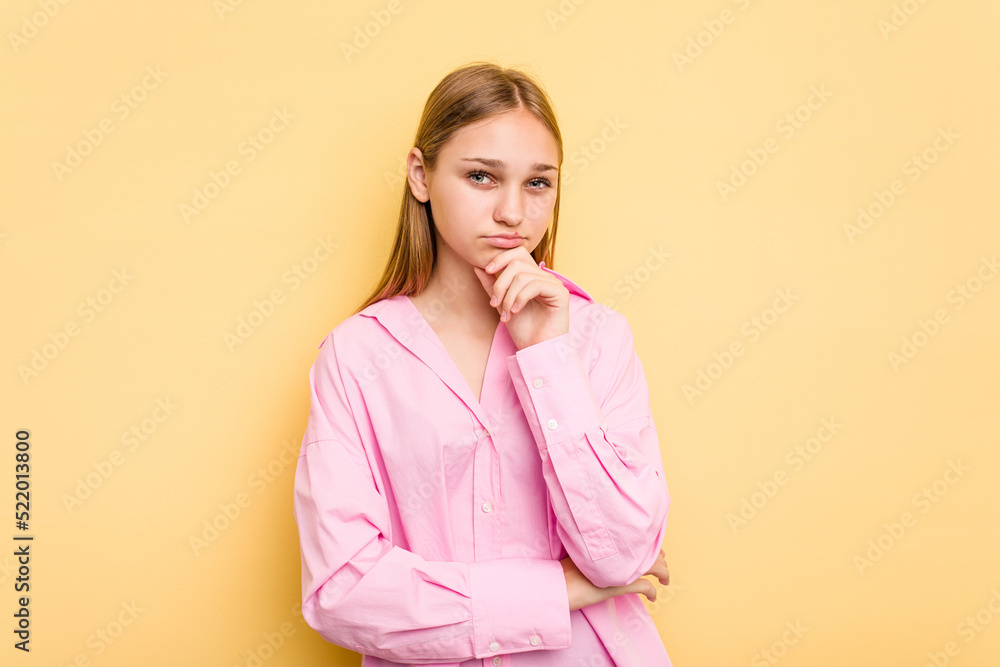 Young caucasian girl isolated on yellow background thinking and looking up, being reflective, contemplating, having a fantasy. Young caucasian girl isolated on yellow background thinking and looking up, being reflective, contemplating, having a fantasy.