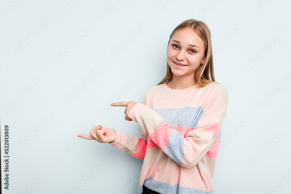 Young caucasian girl isolated on blue background excited pointing with forefingers away. Young caucasian girl isolated on blue background excited pointing with forefingers away.