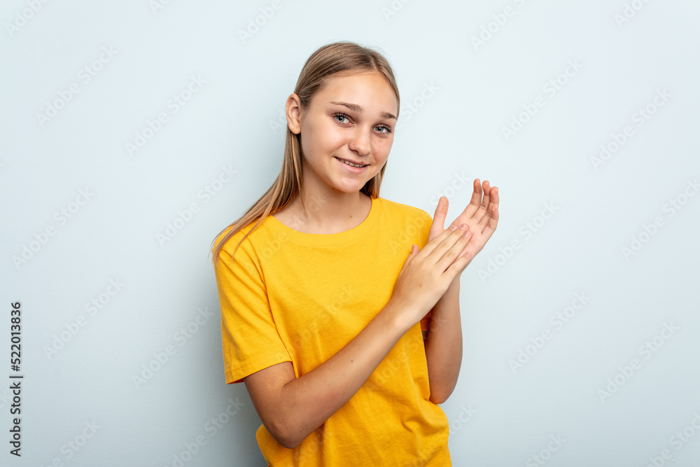 Young caucasian girl isolated on blue background feeling energetic and comfortable, rubbing hands confident. Young caucasian girl isolated on blue background feeling energetic and comfortable, rubbing hands confident.