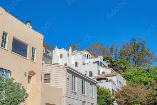 Row of single-family houses along with an apartment building near a slope in San Francisco, CA © Jason