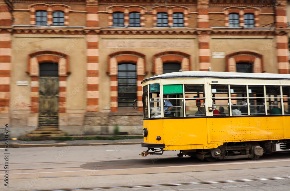 Panning Shot of Yellow Tram in Milan. Colorful Electric Streetcar in Italy.