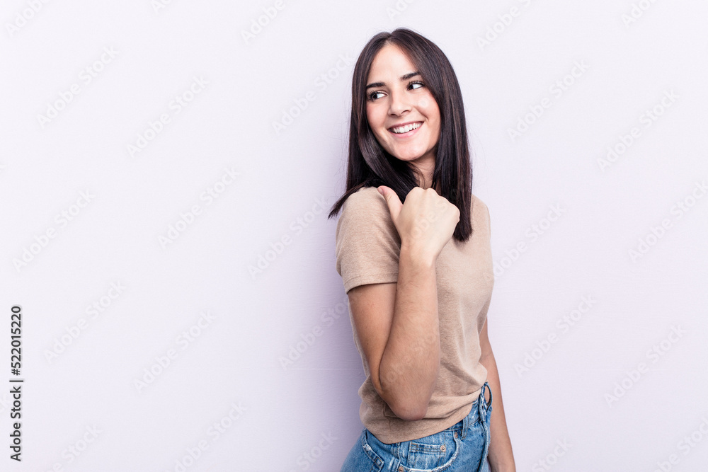 Young caucasian woman isolated on pink background points with thumb finger away, laughing and carefree. Young caucasian woman isolated on pink background points with thumb finger away, laughing and carefree.