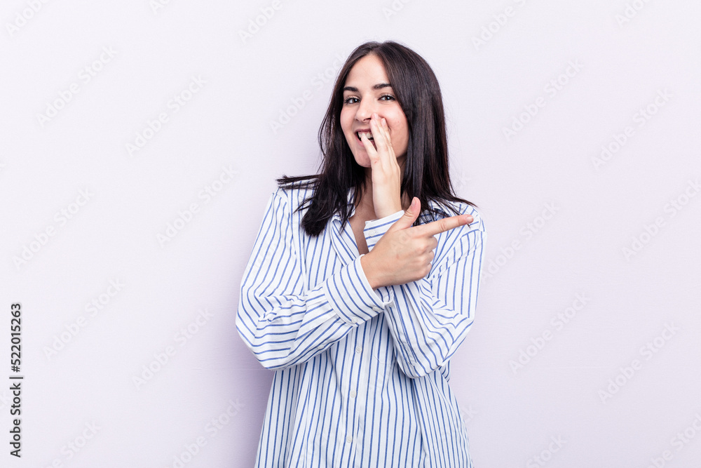 Young caucasian woman isolated on pink background saying a gossip, pointing to side reporting something. Young caucasian woman isolated on pink background saying a gossip, pointing to side reporting something.