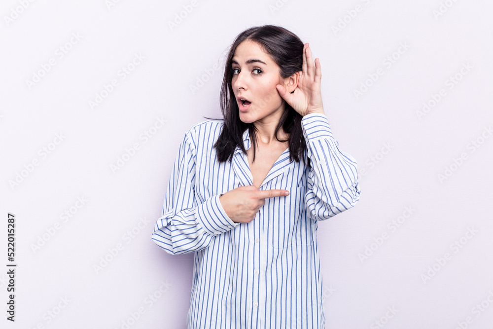 Young caucasian woman isolated on pink background trying to listening a gossip. Young caucasian woman isolated on pink background trying to listening a gossip.