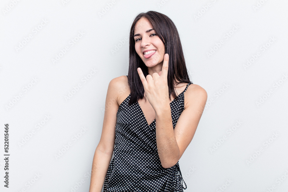 Young caucasian woman isolated on white background showing rock gesture with fingers Young caucasian woman isolated on white background showing rock gesture with fingers