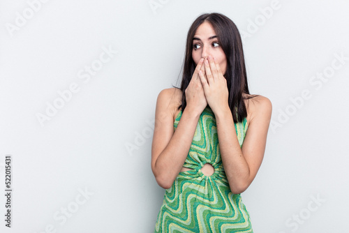 Young caucasian woman isolated on white background thoughtful looking to a copy space covering mouth with hand.