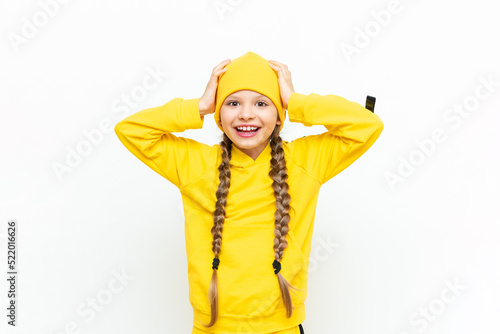 A child in a hat and a yellow tracksuit. Close-up portrait of a smiling little girl. © Юлия Дьякова