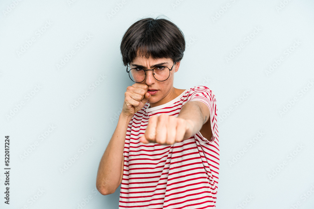 Young caucasian woman with a short hair cut isolated throwing a punch, anger, fighting due to an argument, boxing. Young caucasian woman with a short hair cut isolated throwing a punch, anger, fighting due to an argument, boxing.
