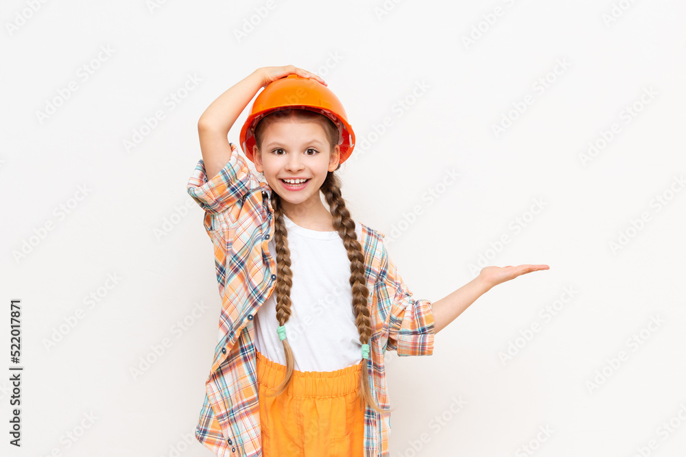 A little girl holds your advertisement in the palm of her hand. The concept of repair and construction. A teenager in a plaid shirt and a protective helmet on a white isolated background. A little girl holds your advertisement in the palm of her hand. The concept of repair and construction. A teenager in a plaid shirt and a protective helmet on a white isolated background.