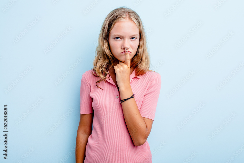 Caucasian teen girl isolated on blue background thinking and looking up, being reflective, contemplating, having a fantasy. Caucasian teen girl isolated on blue background thinking and looking up, being reflective, contemplating, having a fantasy.