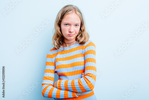 Caucasian teen girl isolated on blue background suspicious, uncertain, examining you.