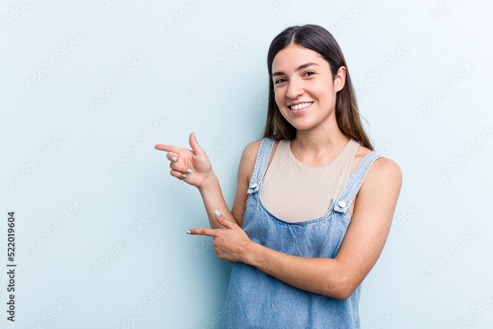 Young caucasian woman isolated on blue background excited pointing with forefingers away. Young caucasian woman isolated on blue background excited pointing with forefingers away.