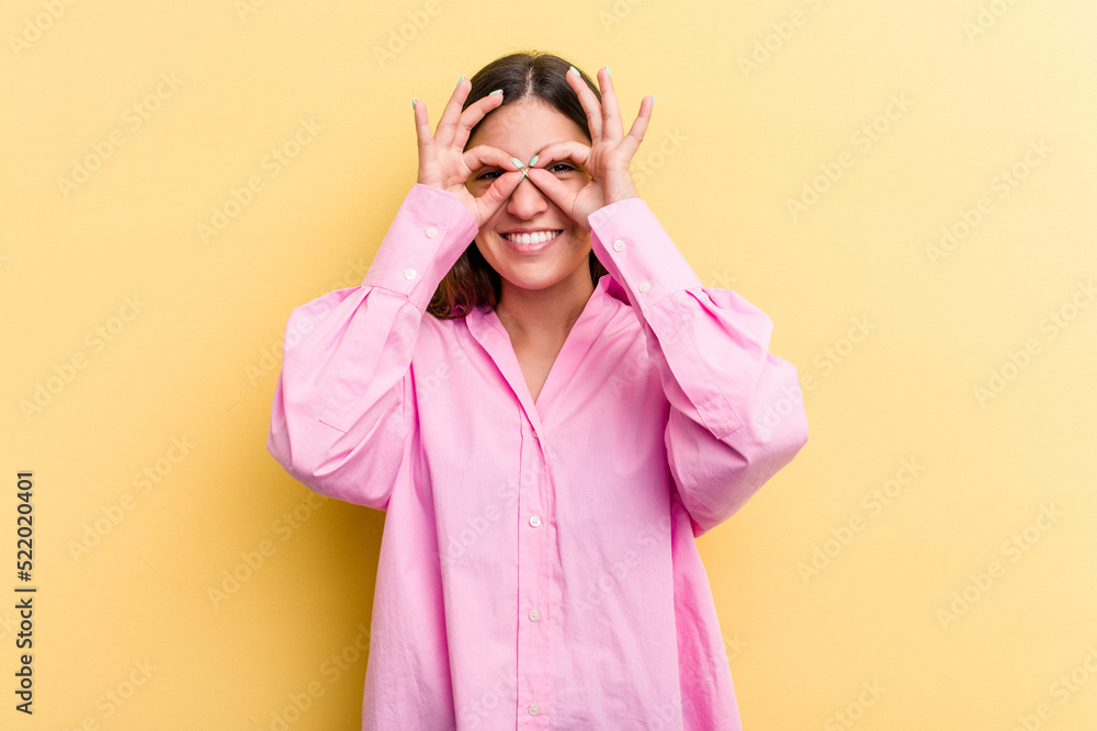 Young caucasian woman isolated on yellow background excited keeping ok gesture on eye. Young caucasian woman isolated on yellow background excited keeping ok gesture on eye.