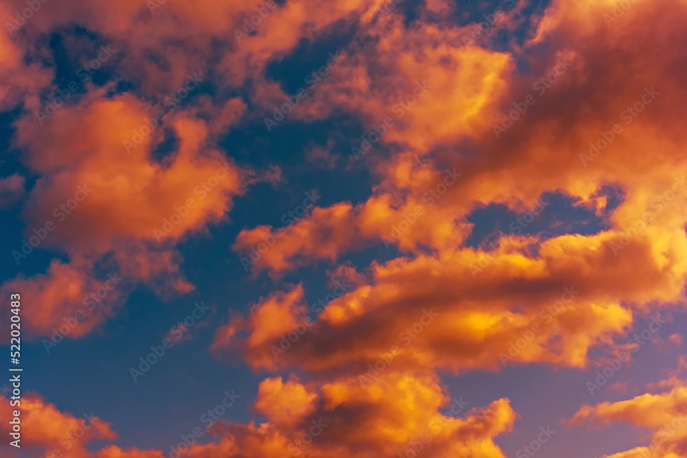 colorful dramatic sky with clouds, smoking cumulonimbus clouds reflect the golden light of the dawn sun.	
