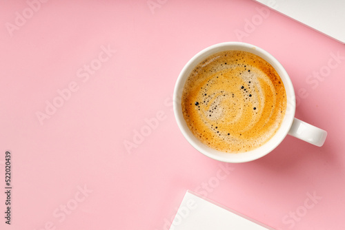 Cappuccino in coffee cup on pink background. Espresso, ristretto drink with foam. Top view, copy space photo