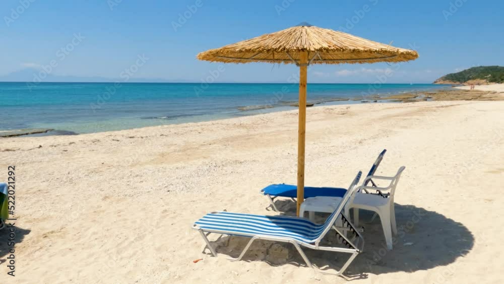Beach chairs and umbrella on the sand beach. Turquoise color of sea. Perfect for relaxing on summer holidays. Travel holiday concept. Beach chairs and umbrella on the sand beach. Turquoise color of sea. Perfect for relaxing on summer holidays. Travel holiday concept.