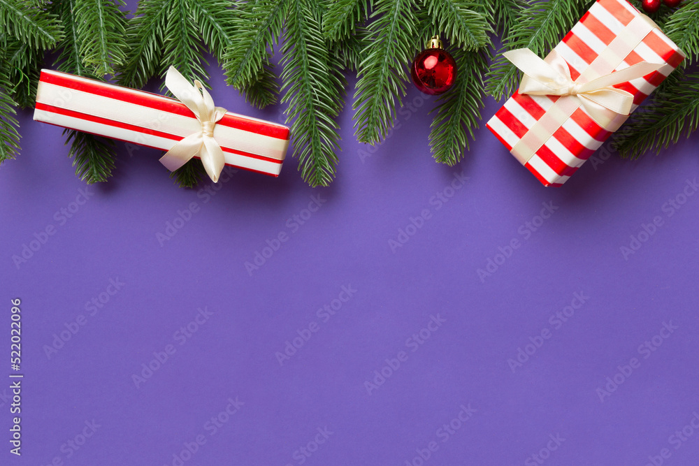 Fototapeta premium Christmas decorations and fir tree branch and gift boxon dark table. Top view frame with copy space