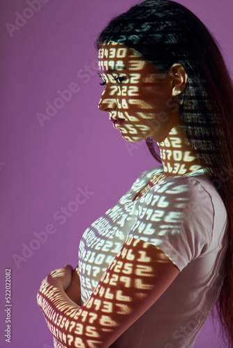 Many of the different numbers. Beautiful young woman is in projector neon lights in the studio