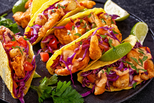 Bang Bang Shrimp Tacos on black plate with sauce