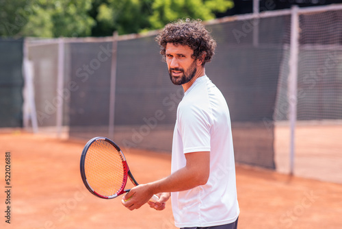 Portrait of tennis player man. front view. looking at camera. on the court