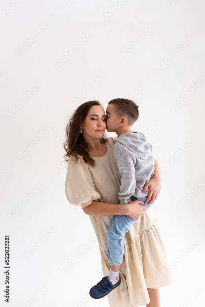 Boy preschooler and mother smile and hug on gray background in photo studio Boy preschooler and mother smile and hug on gray background in photo studio