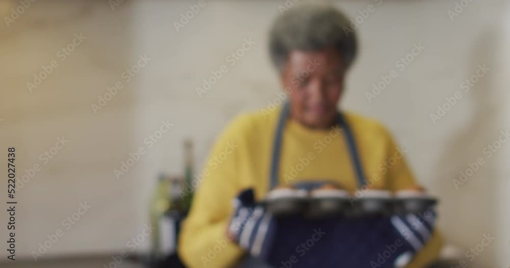 Video of happy senior african american woman holding and smelling tray of freshly baked cup cakes Video of happy senior african american woman holding and smelling tray of freshly baked cup cakes