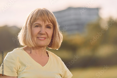 Portrait of happy senior woman that having nice weekend outdoors on the field at sunny day