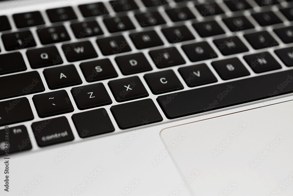 Modern, slim, backlit membrane laptop keyboard. Silver keyboard with thin keys. Selective focus. Modern, slim, backlit membrane laptop keyboard. Silver keyboard with thin keys. Selective focus.
