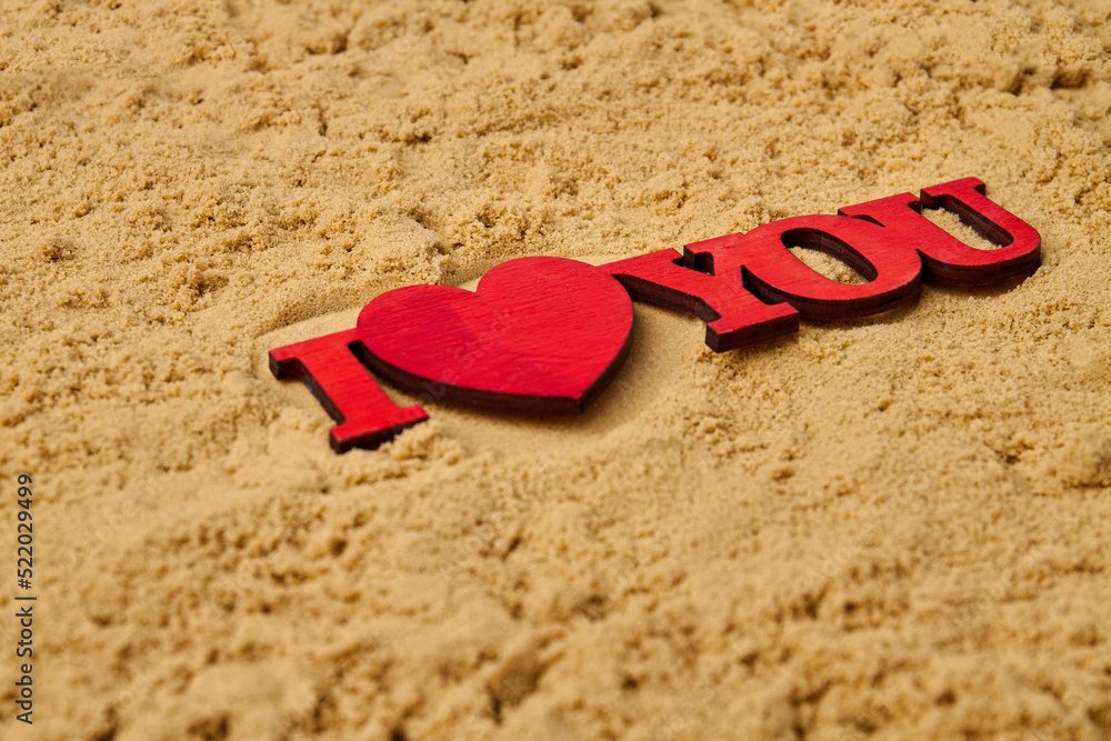 Fototapeta premium Close up red wooden I love you cutout on the sand. Honeymoon vacation concept.