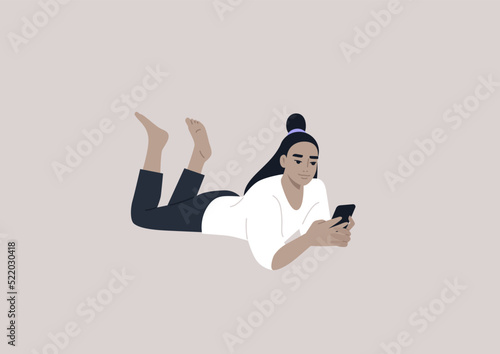 A young female Asian character lying on their stomach and checking their phone