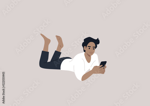 A young male Caucasian character lying on their stomach and checking their phone