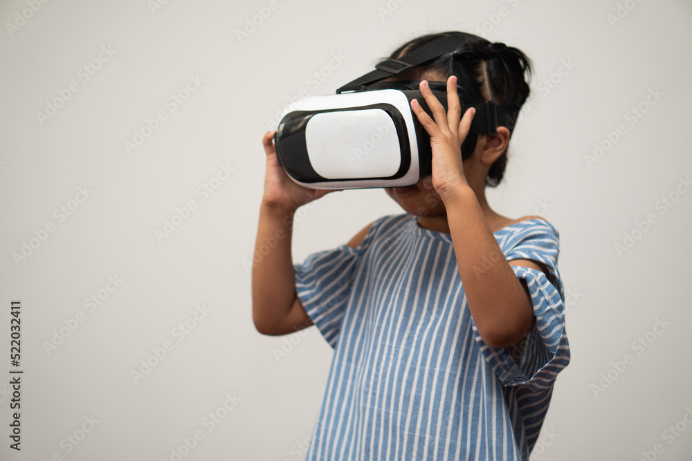 Little Asian girl child with virtual reality headset is exciting for new experiencing. Concept of 3D gadget technology and virtual world gadgets game and online education in the future Little Asian girl child with virtual reality headset is exciting for new experiencing. Concept of 3D gadget technology and virtual world gadgets game and online education in the future