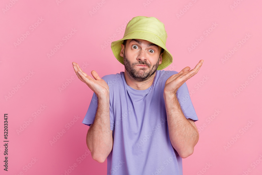 Portrait of attractive clueless guy dressed fashionable clothes shrugging shoulders isolated on pink color background