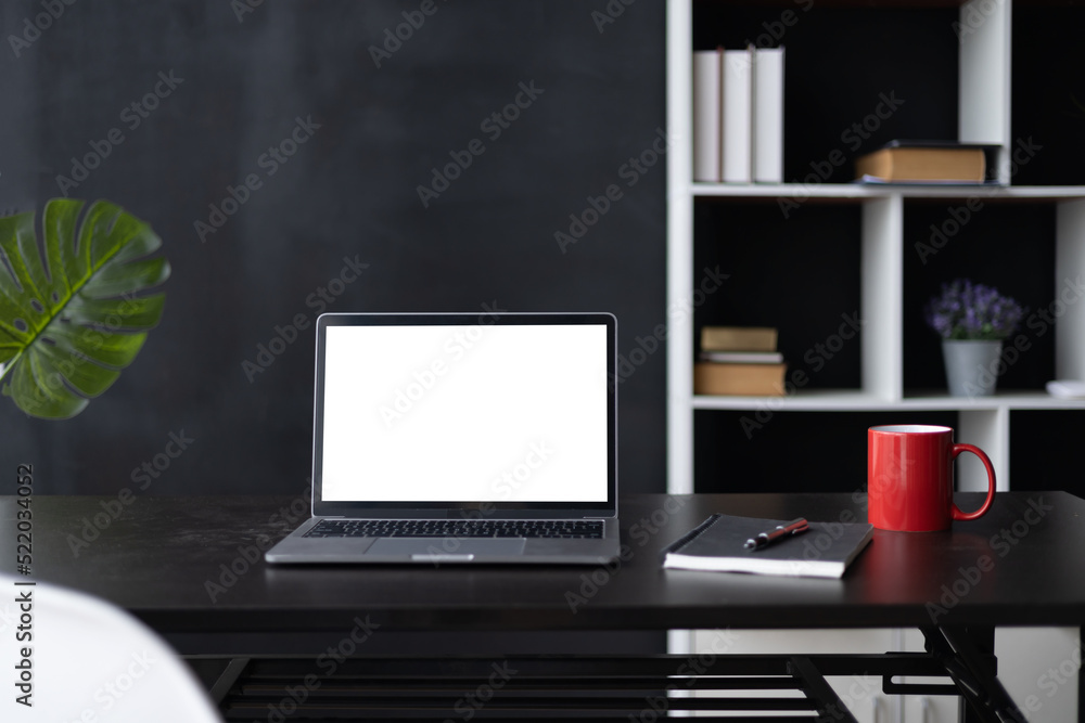 Laptop screen, Laptop Computer, notebook copy space, and eyeglasses sitting on a desk in a large open plan office space after working hours Laptop screen, Laptop Computer, notebook copy space, and eyeglasses sitting on a desk in a large open plan office space after working hours