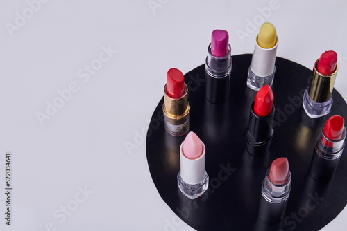 Set of standing multicolored lipstiks on white background. Cosmetic makeup accessories. photo