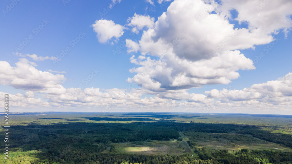 Blue sky panorama with clouds over tops of green trees. Blue sky and white cloud soft. White clouds background.