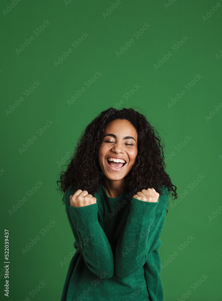 Young black woman laughing while making winner gesture Young black woman laughing while making winner gesture