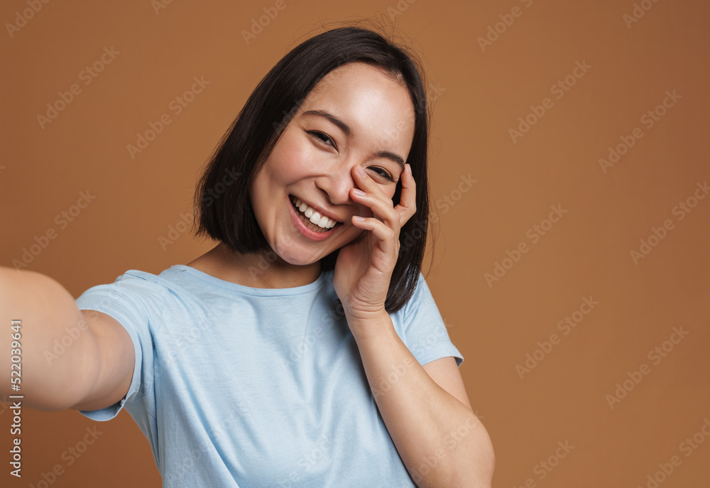 Young asian woman laughing while taking selfie photo Young asian woman laughing while taking selfie photo