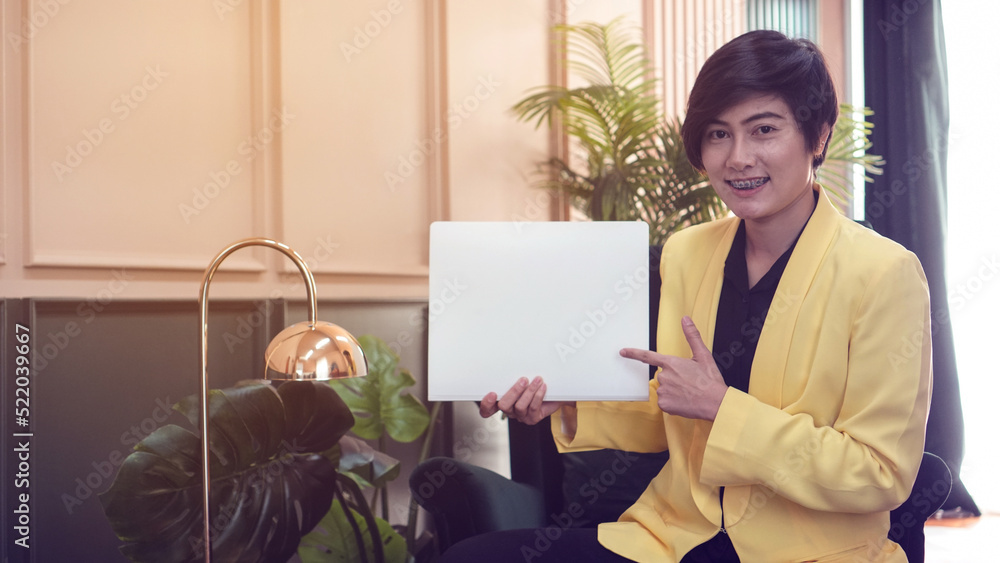 Asian business woman in yellow suit holding copy space sign display Asian business woman in yellow suit holding copy space sign display