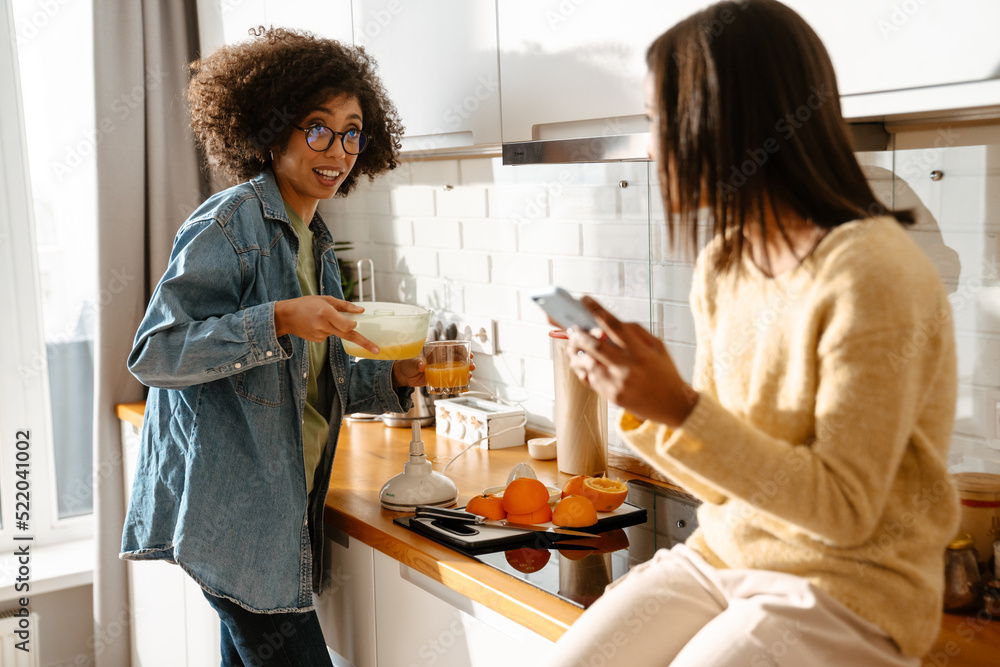 African american woman and daughter making fresh orange juice African american woman and daughter making fresh orange juice