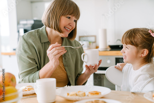 White blonde girl having breakfast with her grandmother