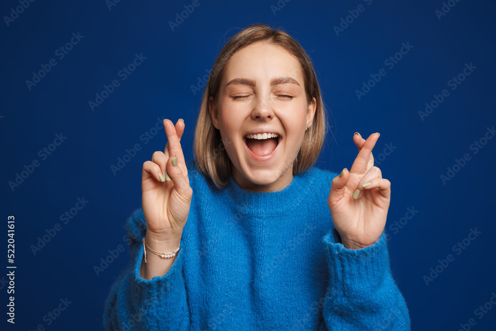 Young hopeful beautiful girl with csossed fingers and closed eyes Young hopeful beautiful girl with csossed fingers and closed eyes