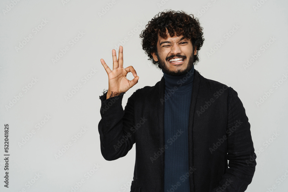 Young handsome curly smiling and winking indian man Young handsome curly smiling and winking indian man