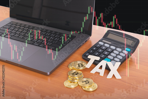 Tax BTC cryptocurrency with TAX wording in front of calculator with laptop on stock graph background