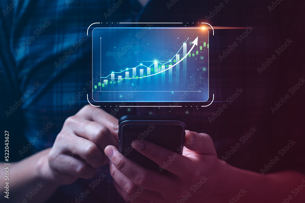 Businessman holding mobile and showing hologram graph and stock market statistics earn profit. business planning and strategy, forex trading analysis. Stock market, growth finance Businessman holding mobile and showing hologram graph and stock market statistics earn profit. business planning and strategy, forex trading analysis. Stock market, growth finance
