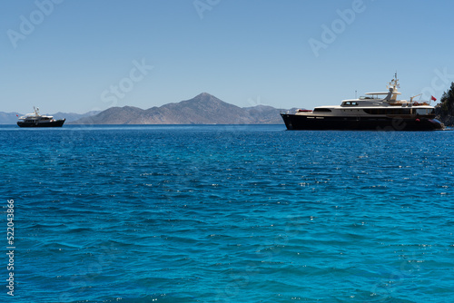 Beautiful emerald Sea and two yachts. Mountains in the background. © sanna