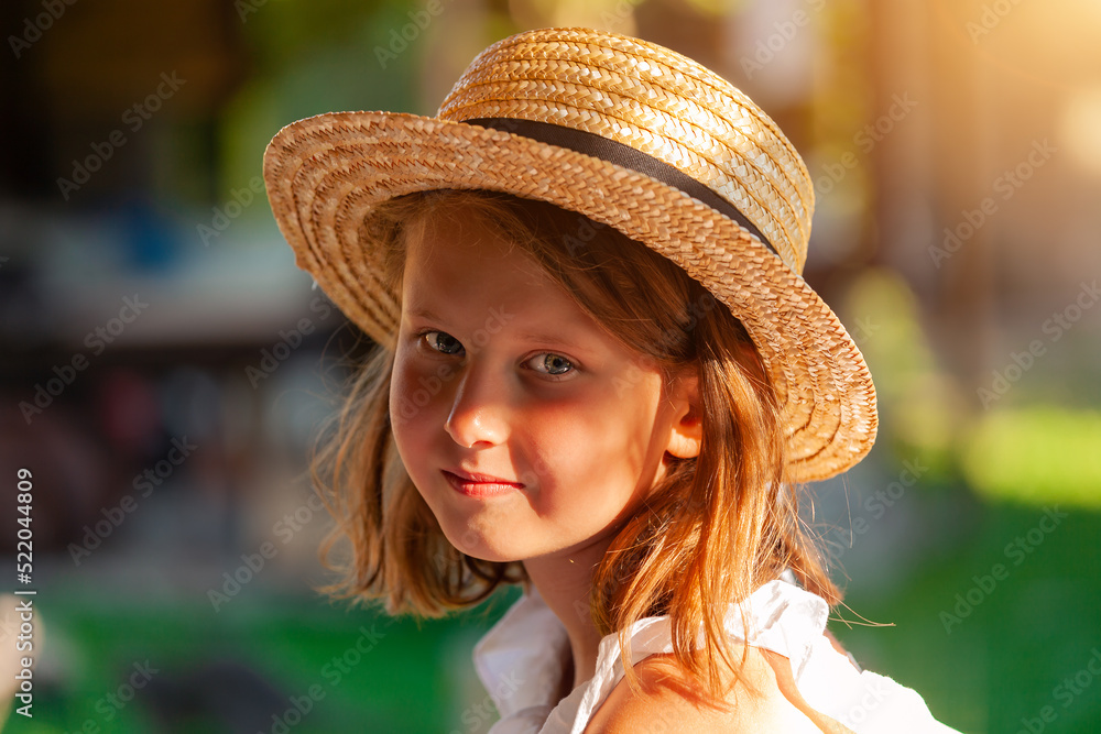 outdoor portrait of cute little girl in straw hat