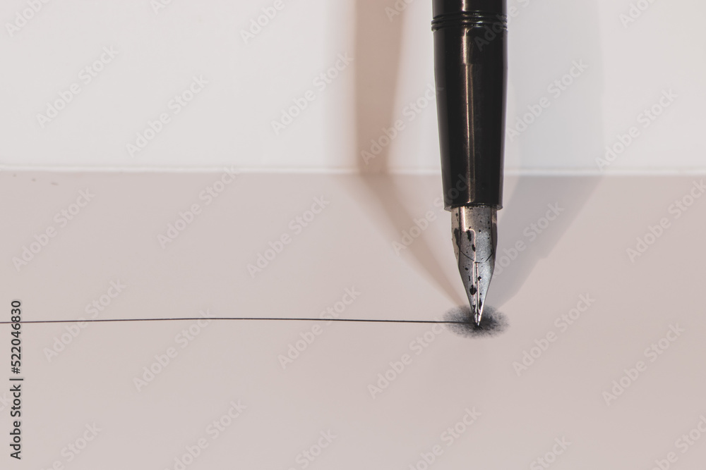 Fototapeta premium silver fountain pen vertical on a white background making a line