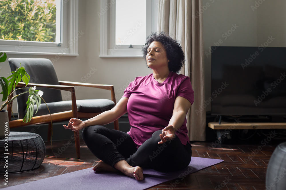 Mature black female practicing medication at home Mature black female practicing medication at home