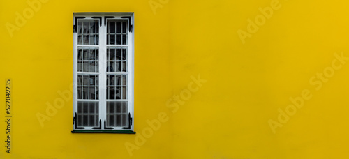 Single window on a yellow wall with room for copy or text.